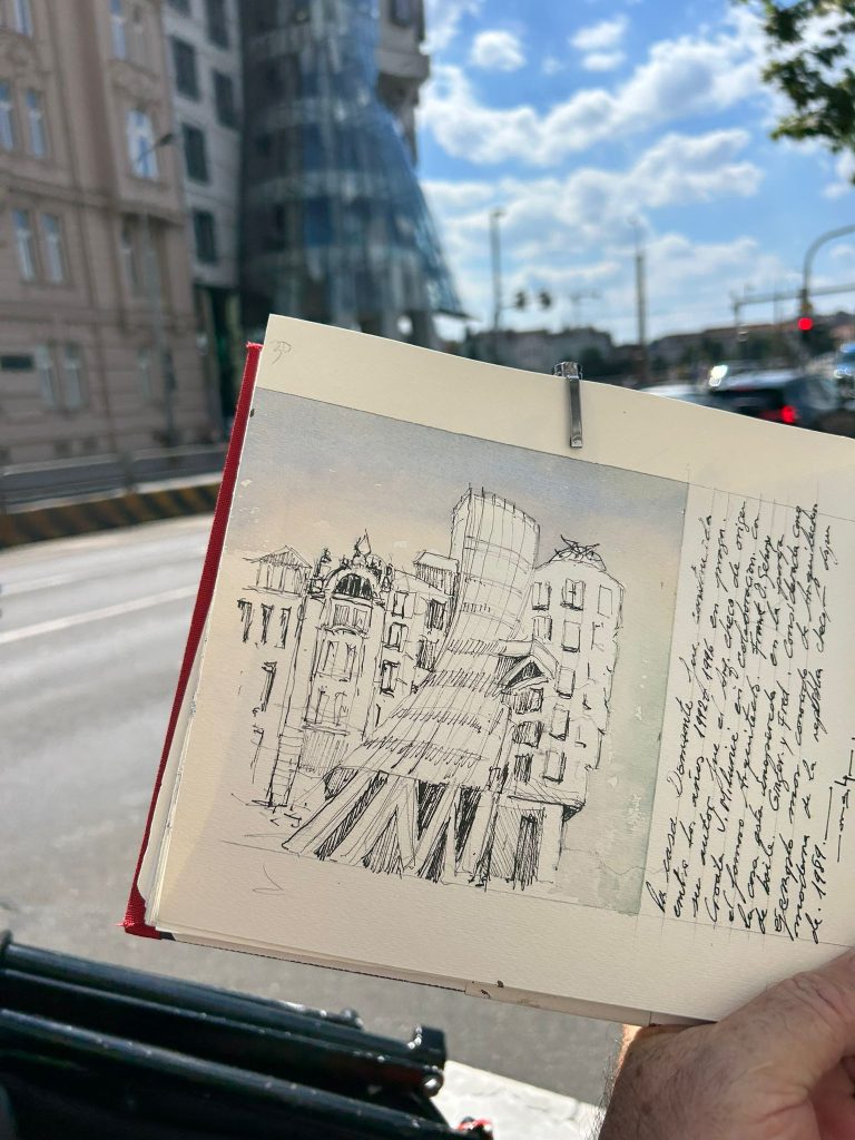 Dibujo de arquitectura a tinta en un cuaderno frente al motivo urbano
