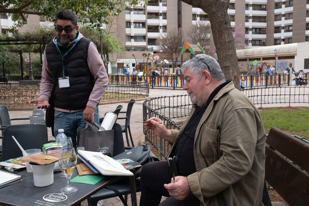 Sesión de pintura con cuaderno y materiales en una plaza